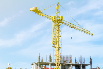 Tower crane on the blue sky background. Building construction work concept, investments in the development construction buildings and structures industry.