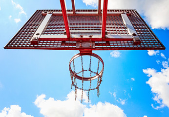Basketball hoop on blue sky background, rear view