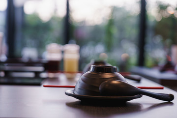 Fototapeta na wymiar Close up lime and shoyu sauce bottle with dish and spoon on shabu shabu table.
