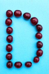Letter D cherry alphabet on blue flat lay