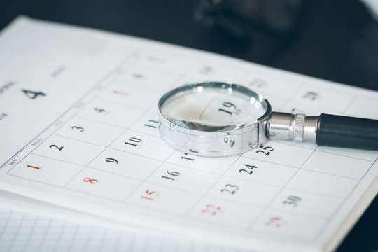 Calendar and Magnifying glass. Concept image of business meetings.