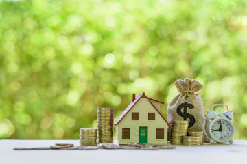 Residential real estate loan, financial concept : House model, coins, US dollar bag, white clock on...