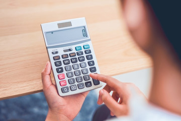 Woman holding and press calculator to calculate income expenses and plans for spending money on...