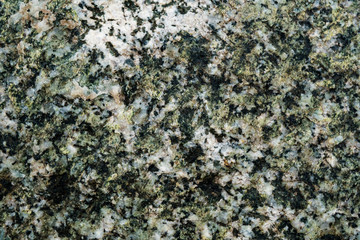 The texture of the stone overgrown with moss. Background image of a boulder