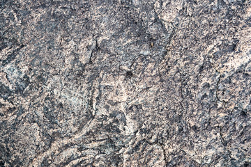 The texture of the stone overgrown with moss. Background image of a boulder