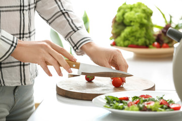 Woman preparing tasty strawberry spinach salad at table