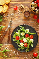 Plate with tasty salad on wooden table