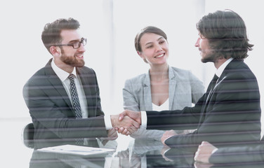 from behind the glass.handshake of business partners