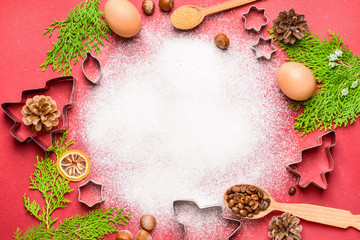 Christmas composition with cookie cutters and flour on color background