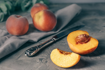 Tasty peaches with knife on grunge background