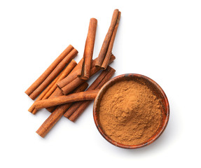 Aromatic cinnamon sticks and powder on white background