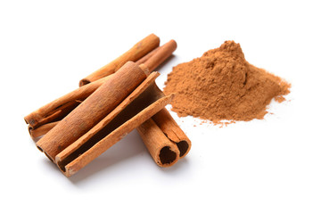 Aromatic cinnamon sticks and powder on white background