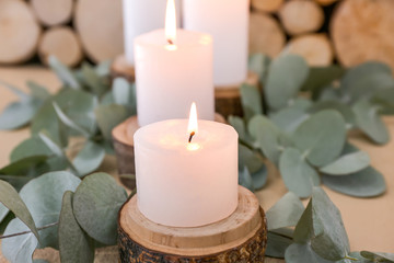 Obraz na płótnie Canvas Beautiful burning candles and eucalyptus branches on table, closeup
