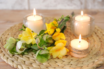 Beautiful burning candles and flowers on table
