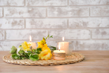 Fototapeta na wymiar Beautiful burning candles and flowers on table