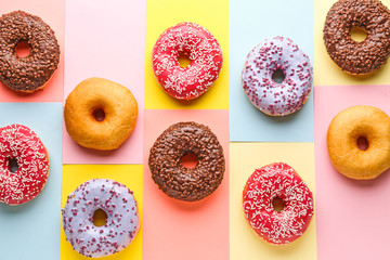 Sweet tasty donuts on color background