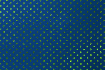 Navy blue background from metal foil paper with a golden green stars pattern.