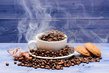Coffee for inspiration and energy charge. Degree of roasting grain. Cafe drinks menu. Fresh roasted coffee beans. Cup full coffee brown roasted beans white clouds of smoke blue wooden background