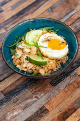 Wok rice cooked with soy sauce, vegetables and chicken pieces.