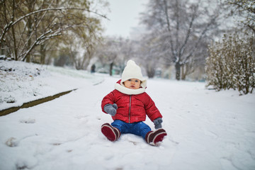 Fototapeta na wymiar Happy smiling baby girl sitting in snow