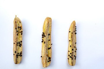 3 Baked Cultivated Bananas with black sesame seeds, Sesamum indicum isolated on white background, Close up & Macro shot, Healthy food concept
