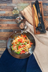 Traditional Thai food papaya salad prepared with fine slices of papaya, tomatoes, green beans and peanuts.
