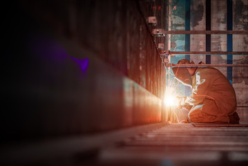 Welder makes welding inside an iron container