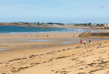 Fototapeta na wymiar Romantic walk of people on the picturesque beach of Saint Malo. Brittany, France