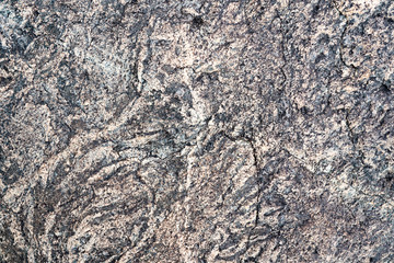 The texture of the stone overgrown with moss. Background image of a boulder
