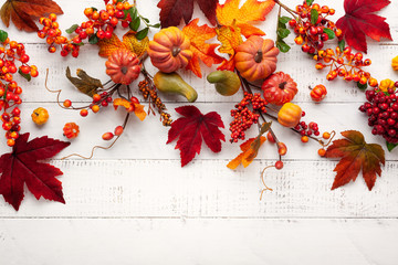 Festive autumn decor from pumpkins, berries and leaves on a white  wooden background. Concept of Thanksgiving day or Halloween. Flat lay autumn composition with copy space.