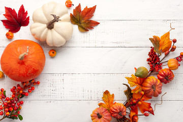 Naklejka na ściany i meble Festive autumn decor from pumpkins, berries and leaves on a white wooden background. Concept of Thanksgiving day or Halloween. Flat lay autumn composition with copy space.
