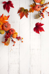 Festive autumn decor from pumpkins, berries and leaves on a white  wooden background. Concept of Thanksgiving day or Halloween. Flat lay autumn composition with copy space.