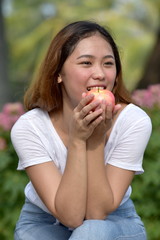 Filipina Female Eating With An Apple