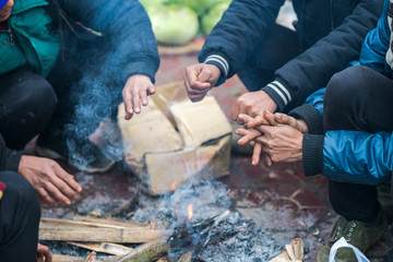 Hands of rural minority people warming up around the fire during the cold weather days in mountaious region in Vietnam