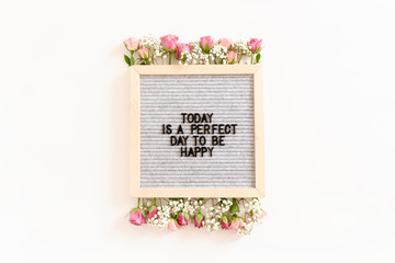 Quote Today is a perfect day to be happy. Letterboard with frame made of flowers on white background