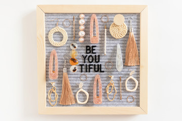 Quote Be You Tiful. Composition with letterboard, earrings, hairpins, rings on white background