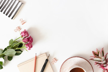 Minimalistic border frame made of flowers, mug of coffee and stationery on white background