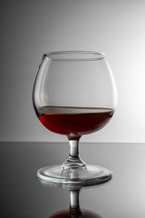 A glass on the table, in the reflection of the bottle.