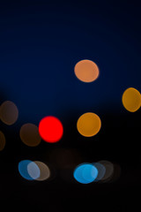 Beautiful specks of color bokeh on a dark background. Vertical.