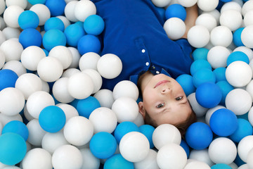 Fototapeta na wymiar Child lying in ball pit