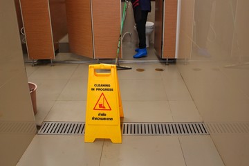 A yellow sign on the floor in the bathroom indicates that the symbol is being cleaned