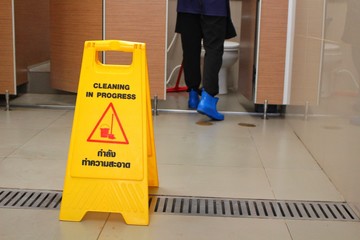 A yellow sign on the floor in the bathroom indicates that the symbol is being cleaned