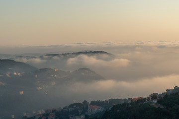 Beautiful colorful sunset over the mountain range and pine tree forest. Nature landscape. fogy sky with some orange reflections.