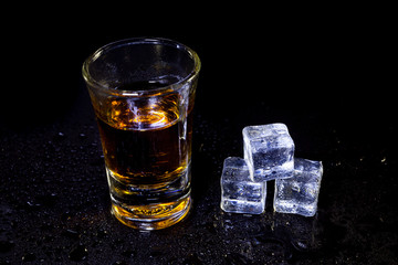 .Whiskey in glass shots with ice cubes.