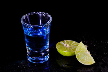Blue vodka in glass and lemon with salt.