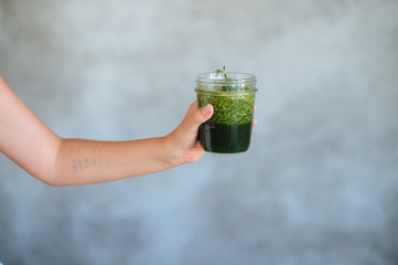 Attractive dieting girl holding healthy green juice showing dislike gestures boring of diet detox...