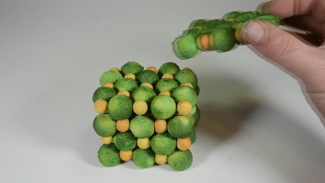 Detaching an atom model of a salt crystal in layers, yellow is sodium, green is chlorine.