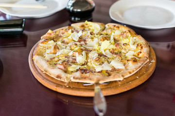 Freshly made pizza on the table. Preparing to eat.