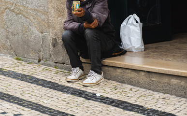 homeless beggar man sitting outdoors and asking for money help.