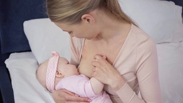 overhead view of woman breastfeeding baby at home